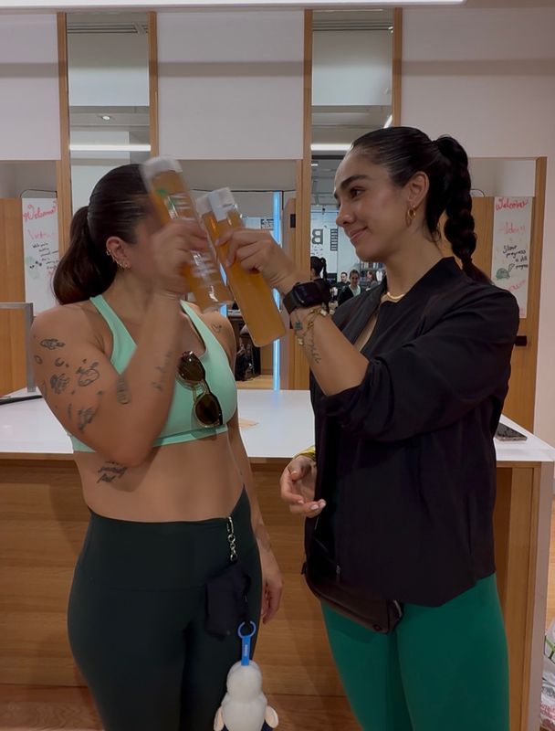 Dos mujeres brindando con Releaf Tea en el gym