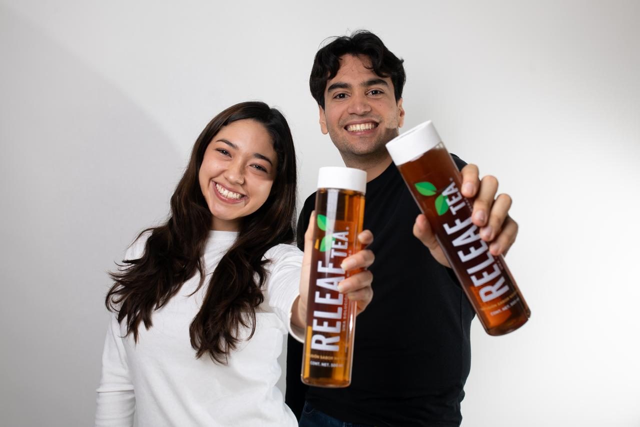 Los fundadores de Releaf Tea sosteniendo sus botellas